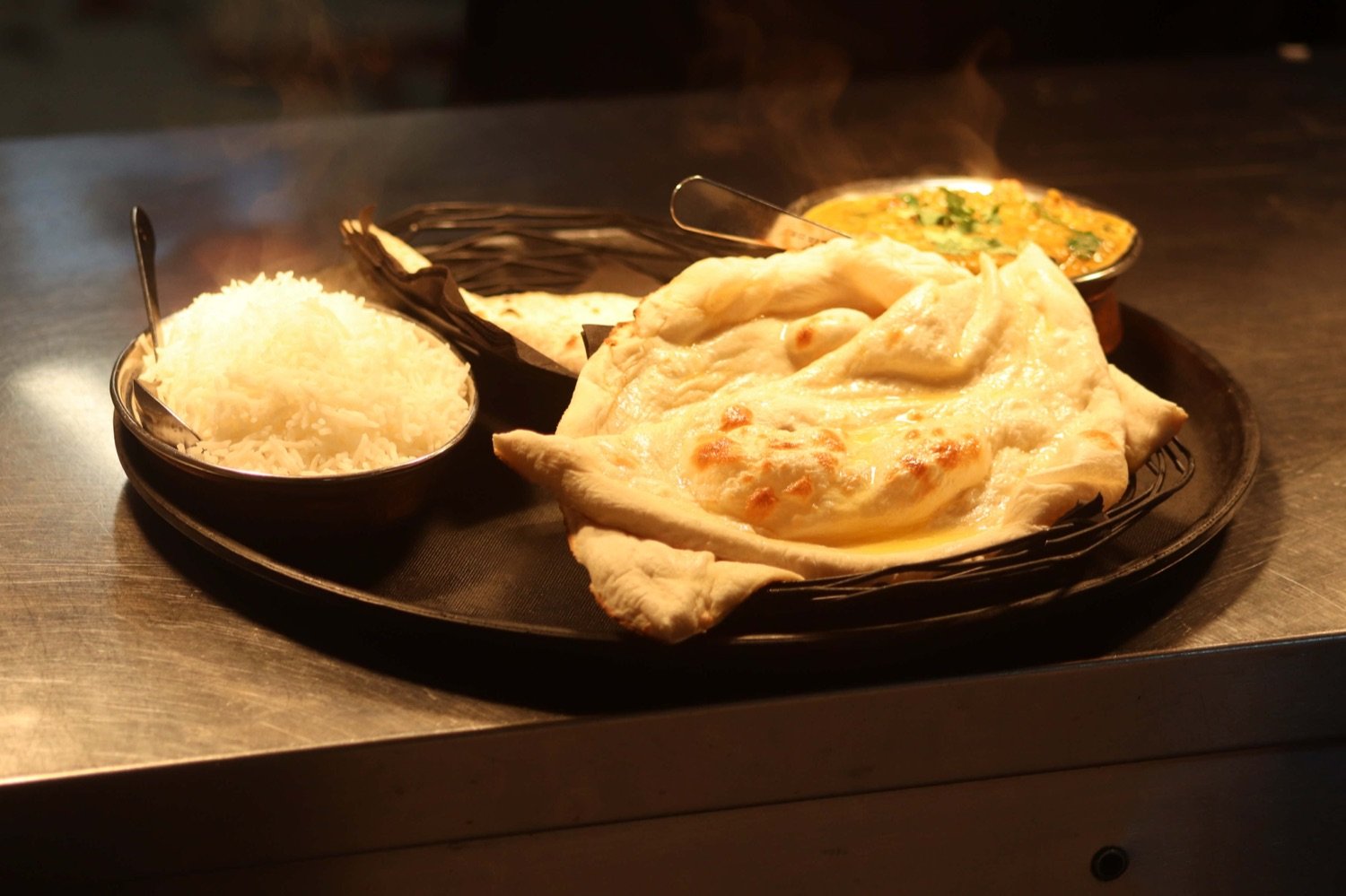 Fresh naan, basmati rice and daal steaming on the pass
