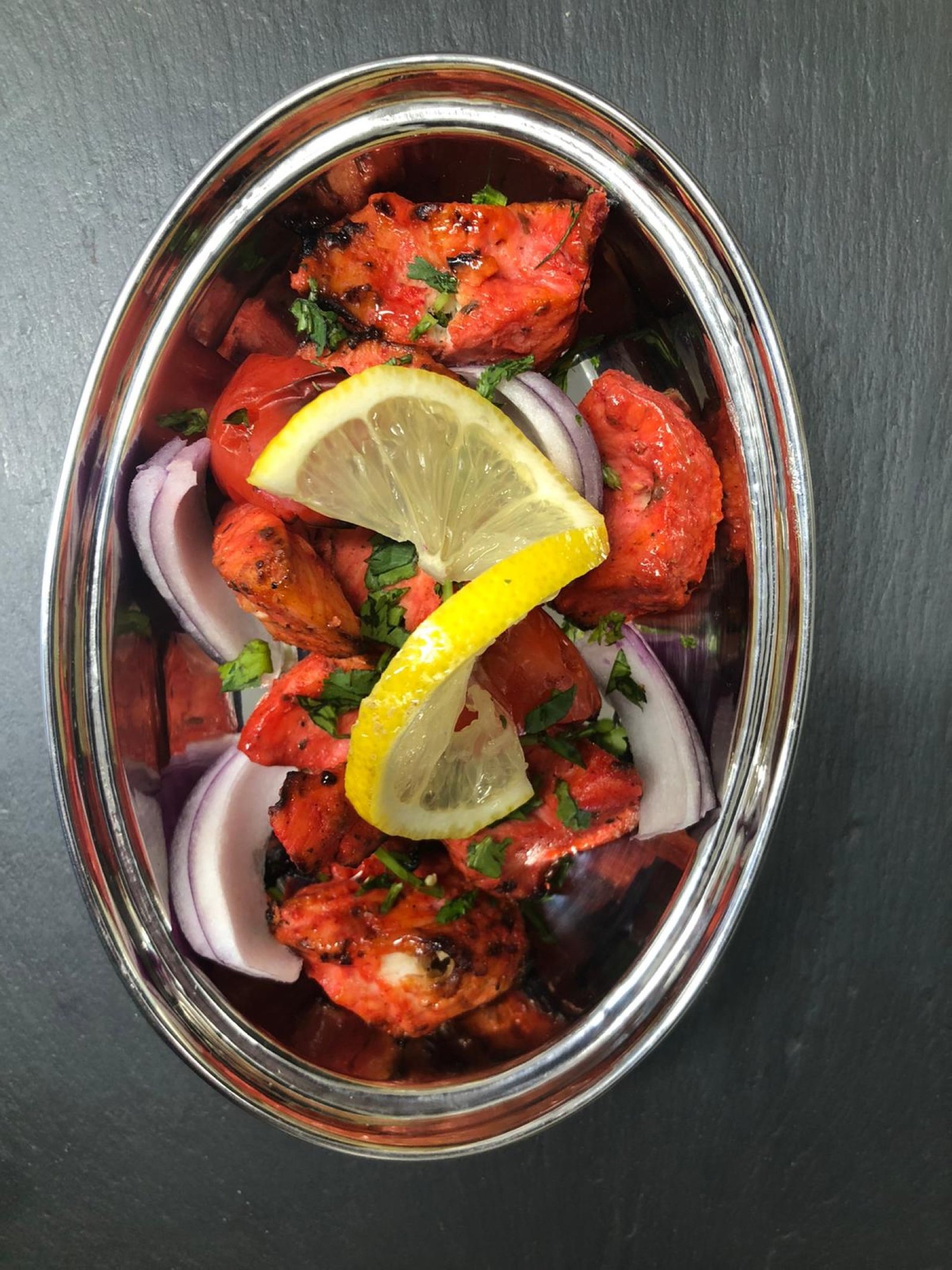Chicken tikka deep in its red spice marinade